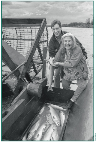 Katie John and Bob Anderson gathering salmon at the Chistochina fish wheel.
