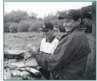 Freddy Nicolai Jr. and Chester Pence cutting salmon at Batzulnetas.