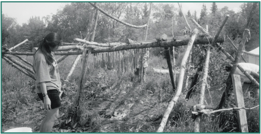 Mariah Craig drying salmon strips for winter storage at Batzulnetas.
