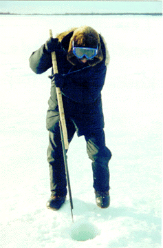 Levi Hoover cuts a hole for jigging. He pounds the ice with the ice pick.