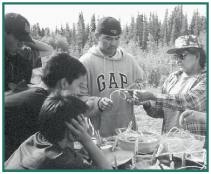Derrick Neal, John Nicolai, Freddy Nicolai, and Daniel Nicolai learn how to make baskets from Molly Galbreath.